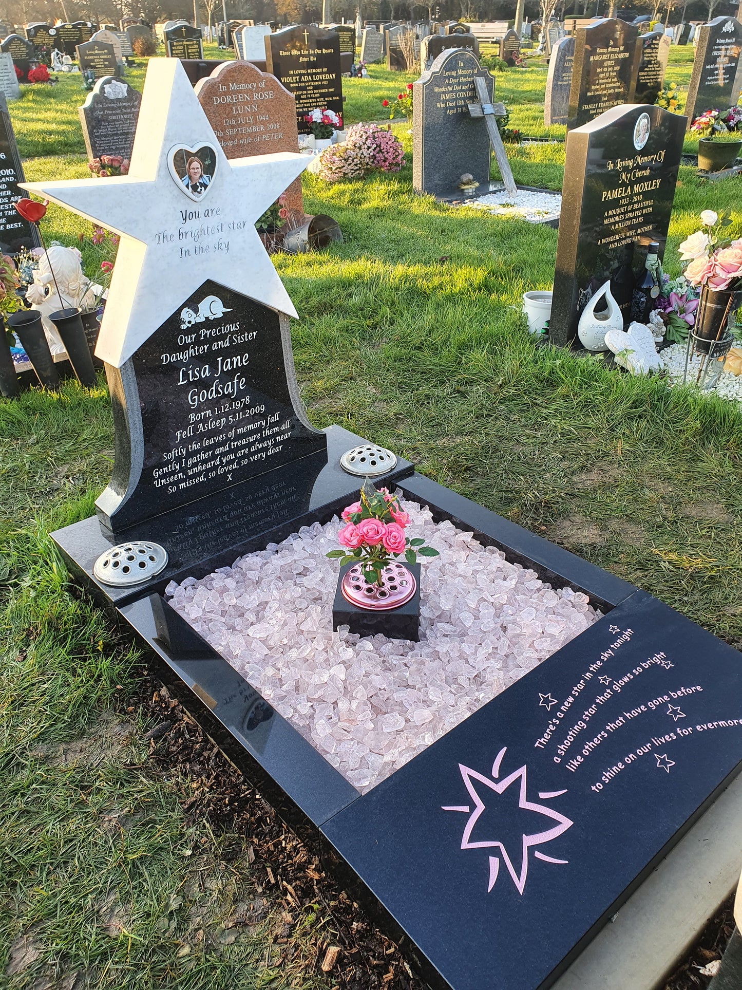 Carved teddy holding a star memorial on square base