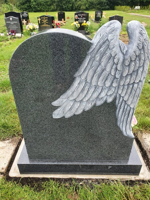 Carved angel leaning over heart with square base