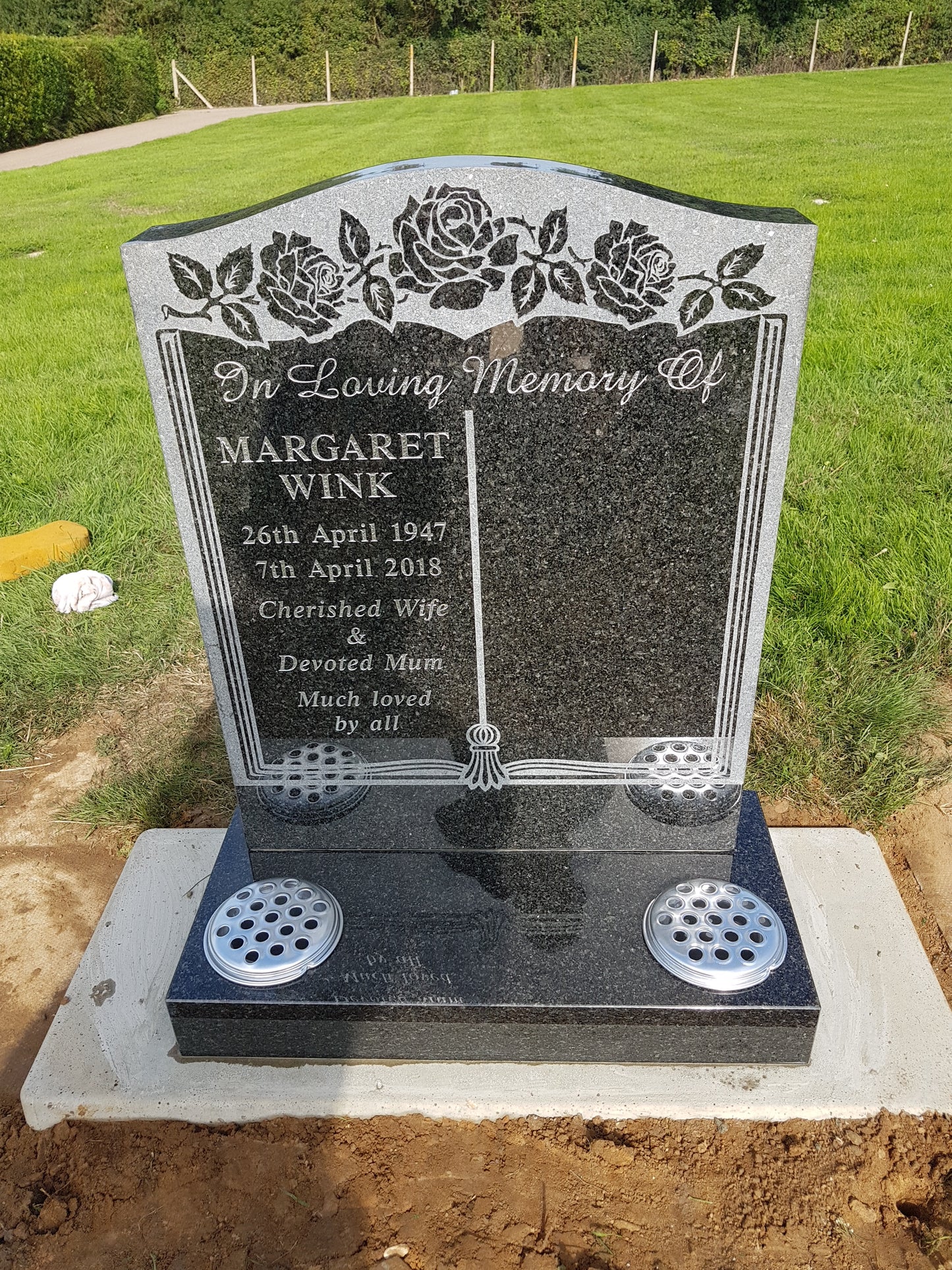 Carved panel memorial with carved cross and roses