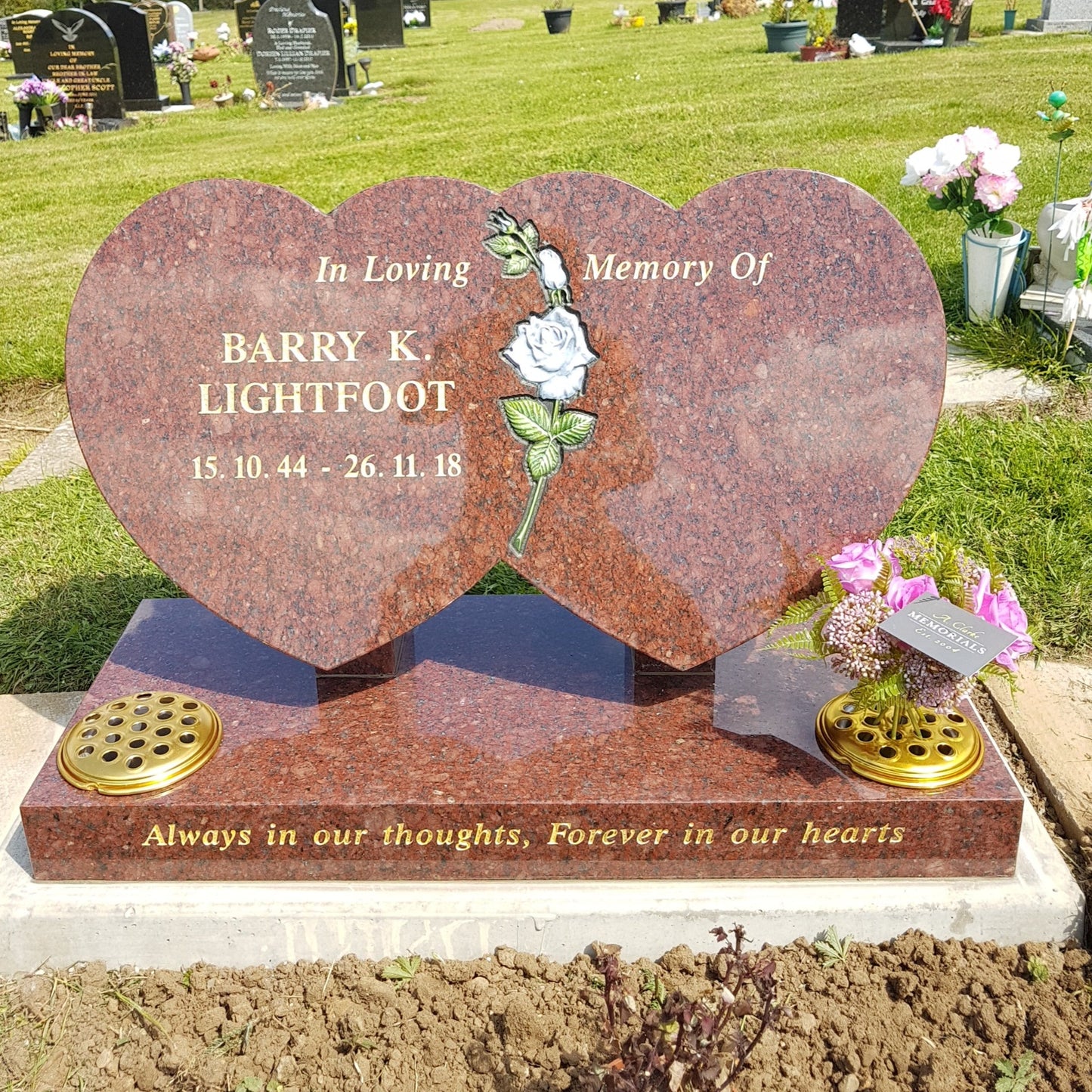 Double heart memorial with carved lily to centre
