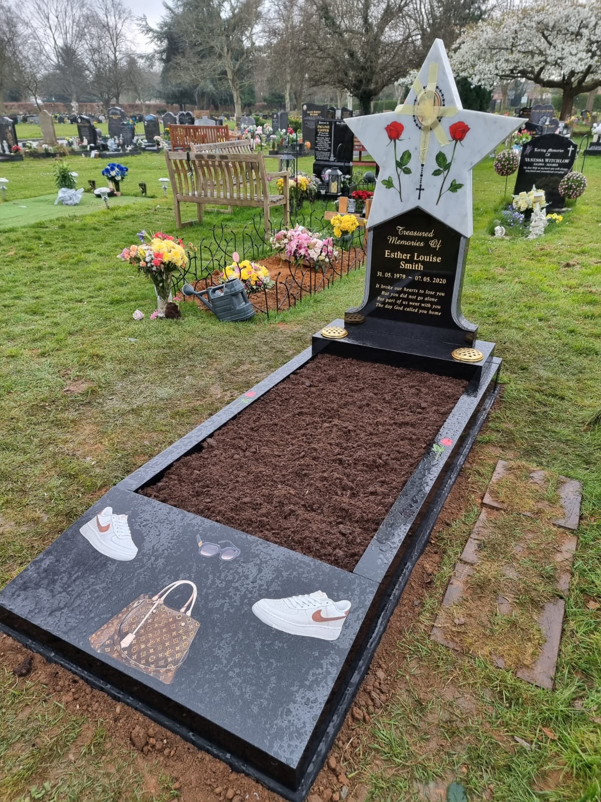 Carved teddy holding a star memorial on square base