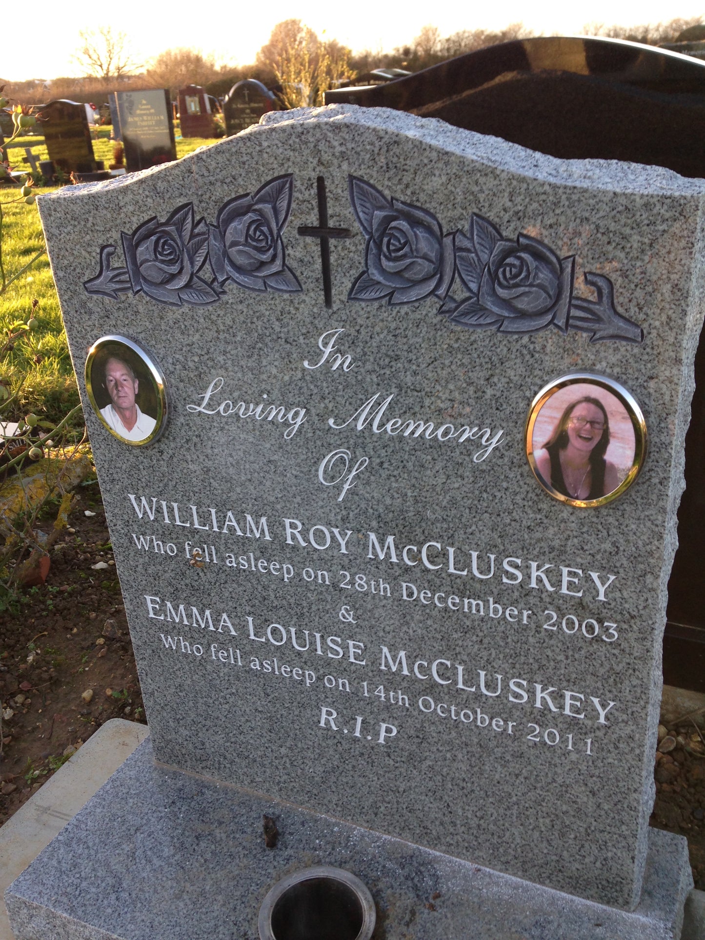 Carved panel memorial with carved cross and roses