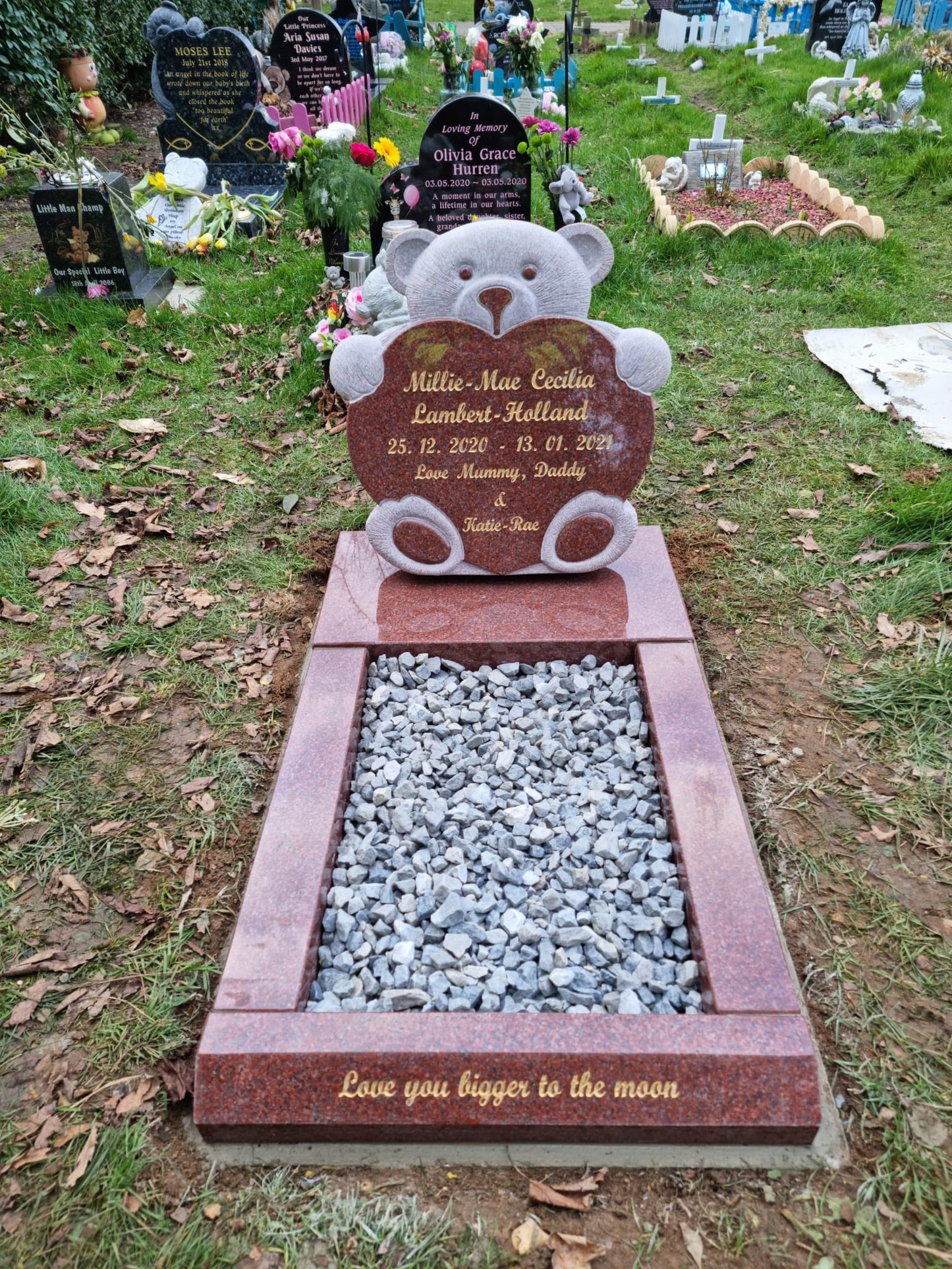 Carved teddy holding a star memorial on square base