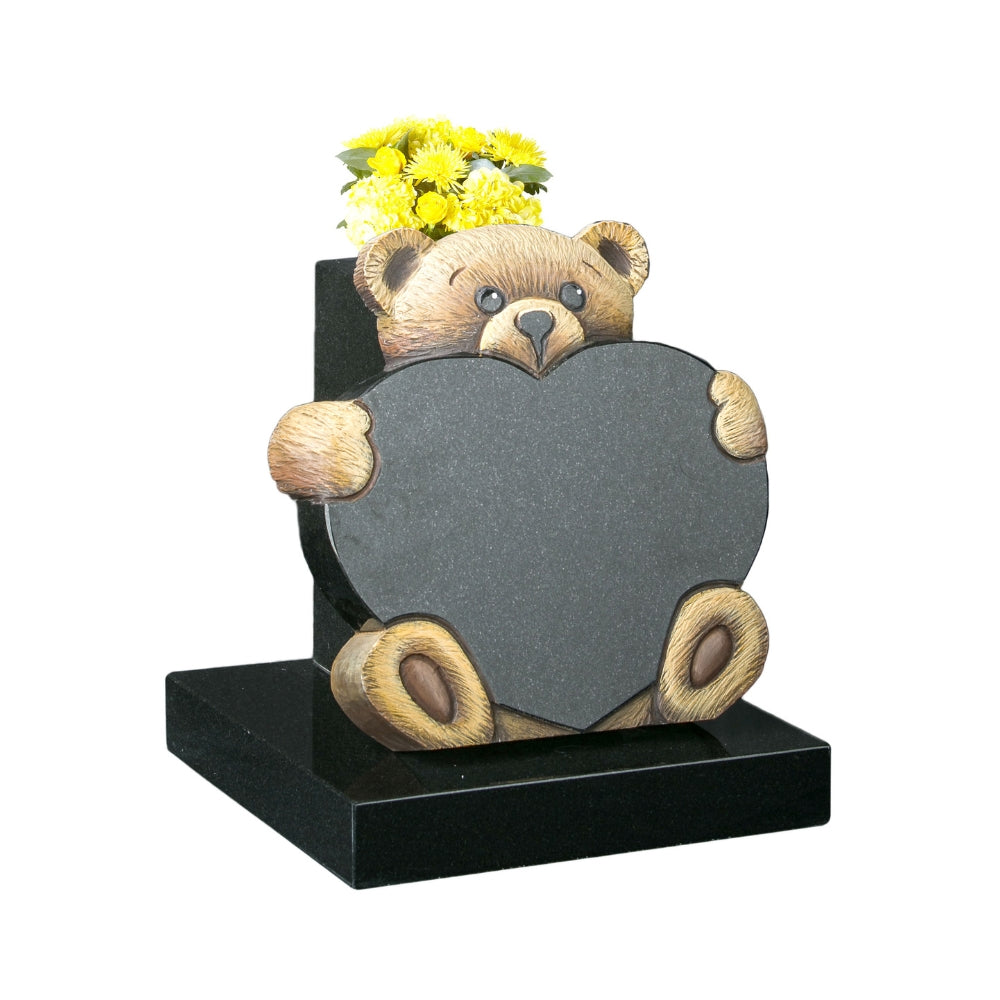 Carved teddy bear holding heart memorial with vase to rear
